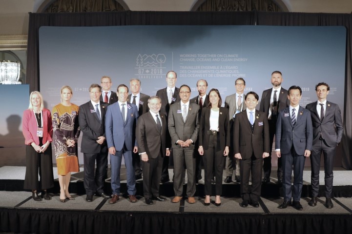 Les délégués des pays du G7 prennent la pose pour une photo de famille, portant leurs épinglettes Parité d’ici 30.